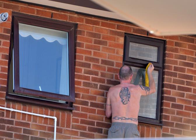 L'ex giocatore Paul Gascoigne fotografato mentre pulisce le finestre del suo attico a Boscombe, Bornemouth (Olycom)